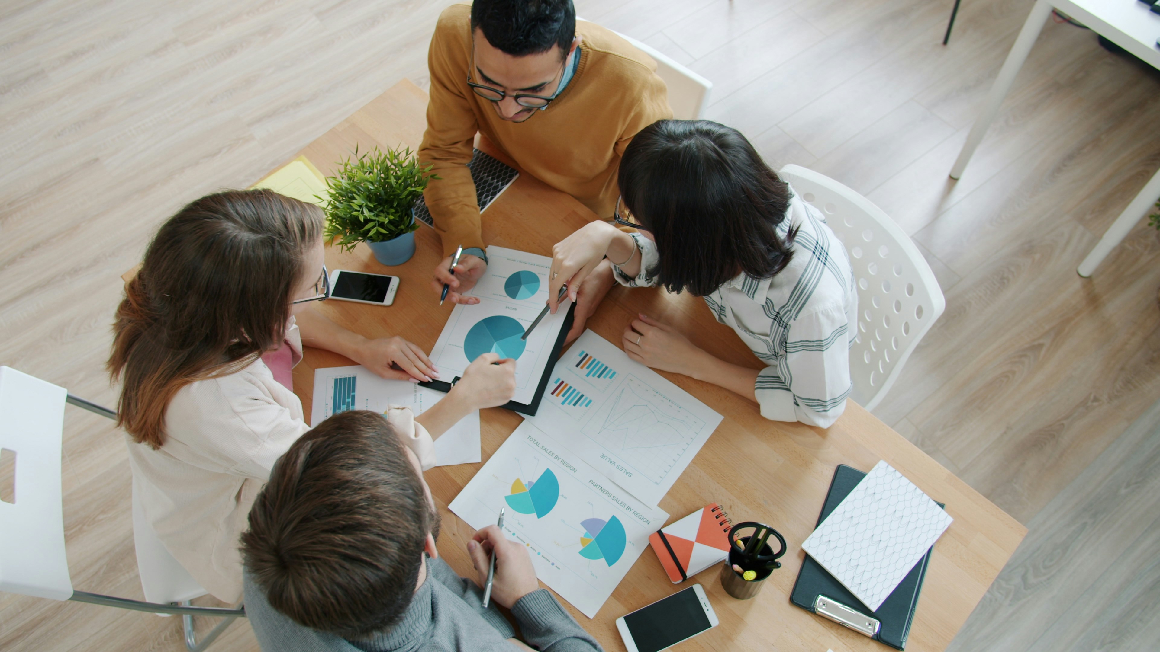 Team of advisors analysing charts around a table